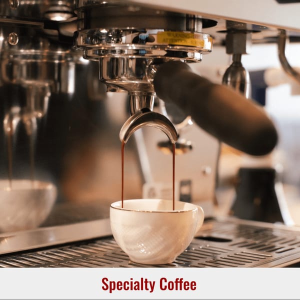Espresso machine pouring two streams of dark coffee into a white cup at Dessert Avenue.